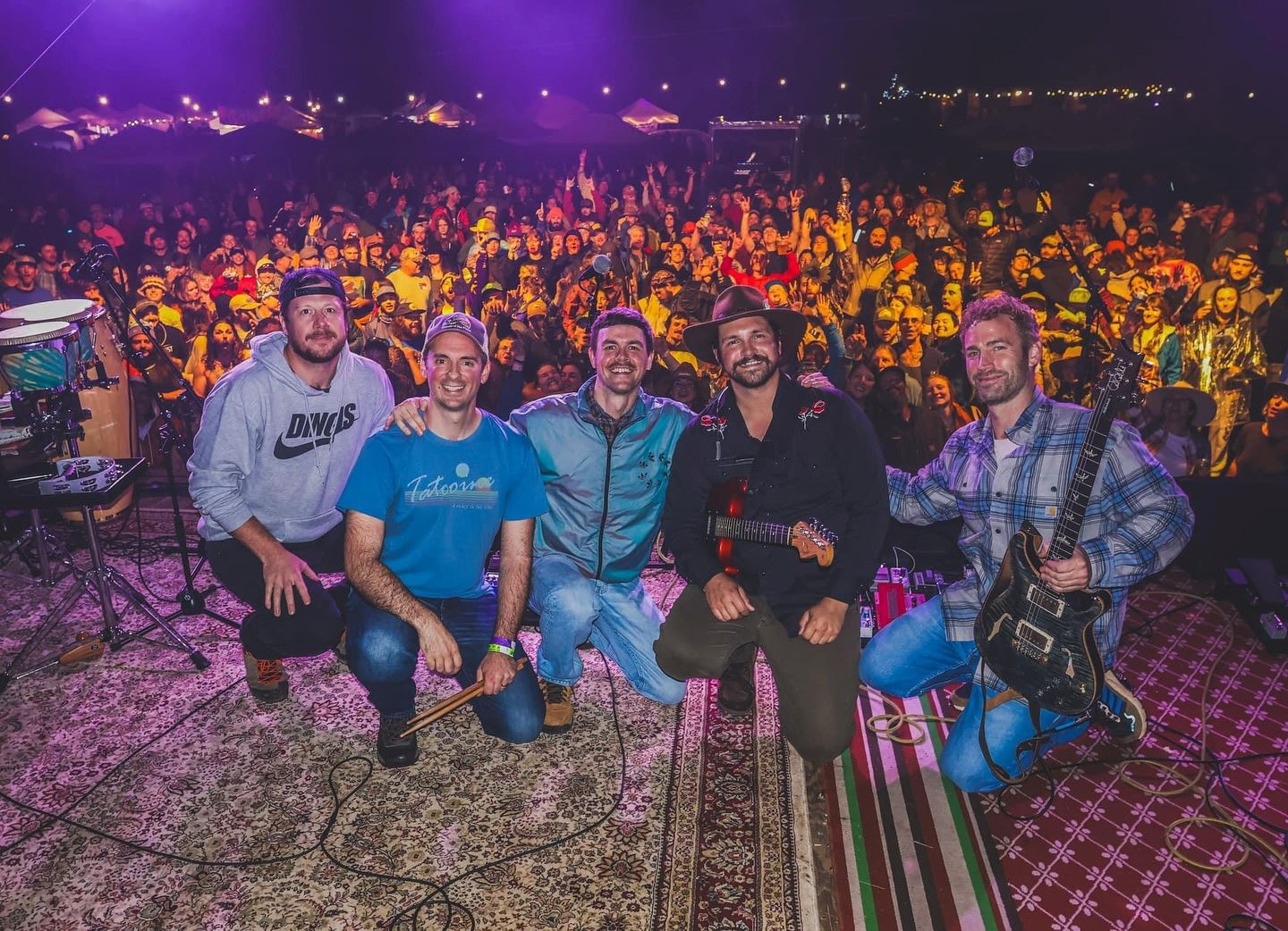 Fletcher's Grove kneeling at the front of the stage with a cheering crowd behind them